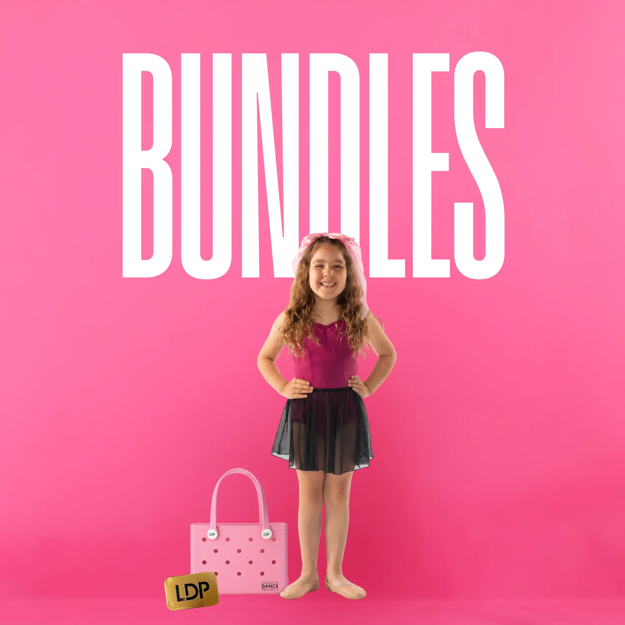Young dancer in a leotard and skirt next to a pink LDP tote bag